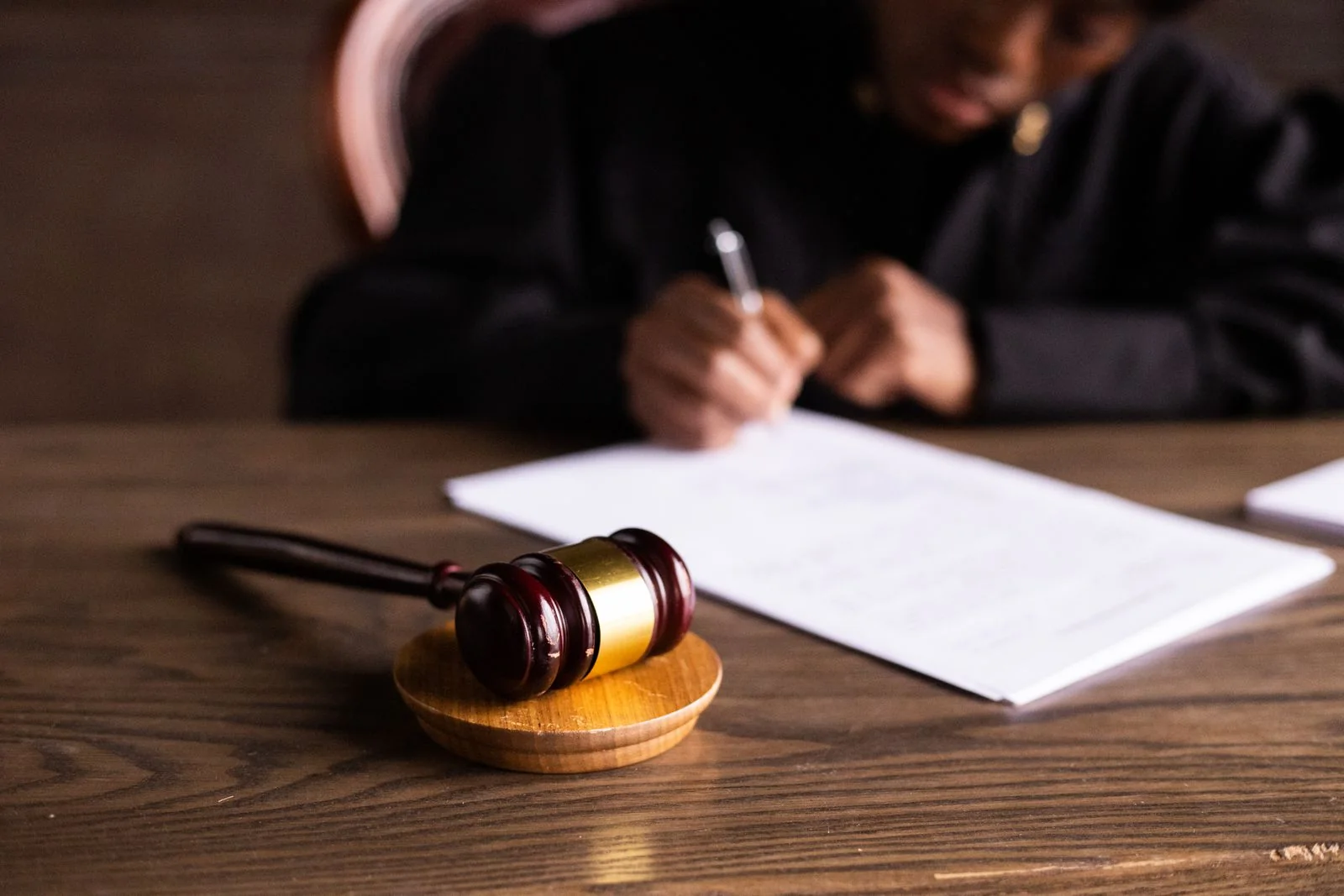 Firma de documentos en una escena preparada sobre el ámbito jurídico. Fotografía de recurso; no representa a la comisionada ni la tramitación parlamentaria.